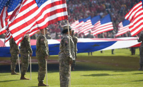 Veterans in uniform holding flags